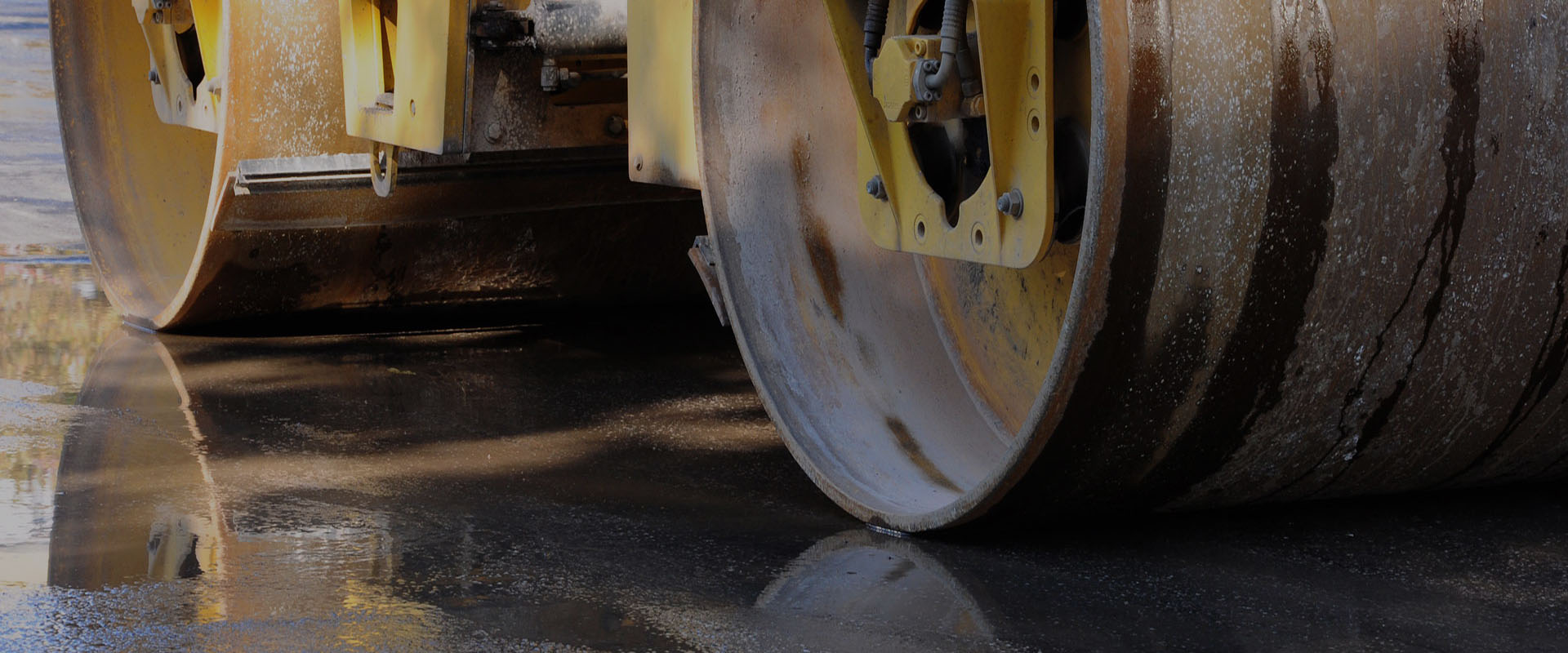Twin drum roller compacting a fresh asphalt surface