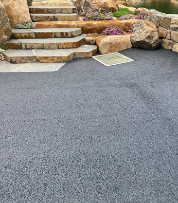 New asphalt driveway running down to a rural home